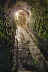 old tunnel moistened with water channel carved in the rock