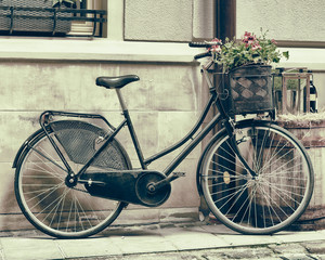 Fototapeta na wymiar Vintage, stylizowane zdjęcie Stary rower niosąc kwiaty