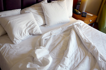 Fototapeta na wymiar hotel bed with ruffled sheets