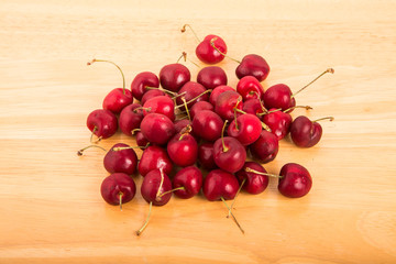 Cherries and Stems on Wood Board