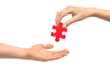 Woman hand give red puzzle to man hand isolated on white