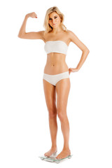 Naklejka premium Muscle Woman Standing on Bathroom Scales.