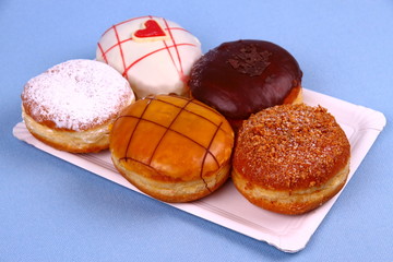 Five delicious, assorted donuts on plate