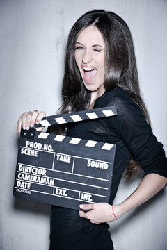 Beautiful woman holding clapperboard