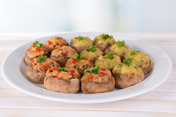 Stuffed mushrooms on plate on table on light background