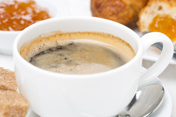 cup of black coffee, fresh croissants and jam, close-up