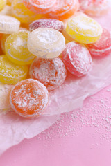 Sweet  multicolor candies on paper, on color background