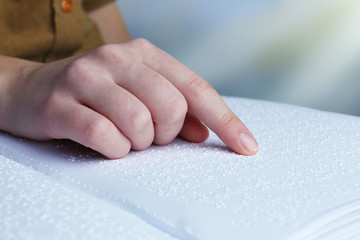 Blind woman read book written in Braille