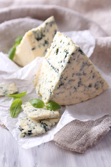 Tasty blue cheese with basil on paper