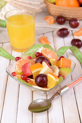 Sweet fresh fruits in bowl on table close-up