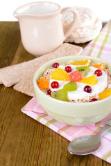 Delicious oatmeal with fruit in bowl on table close-up