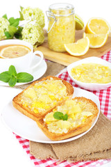 Delicious toasts with lemon jam on plate on table close-up