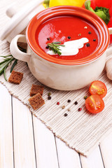Tasty tomato soup and vegetables on wooden table