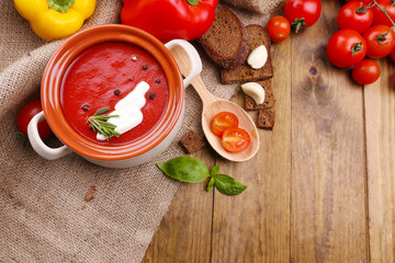 Tasty tomato soup and vegetables on wooden table