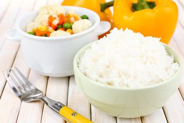Cooked rice with vegetables on wooden table close up