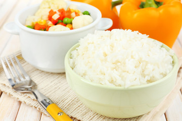 Cooked rice with vegetables on wooden table close up