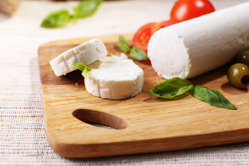 Tasty bushe cheese with tomatoes, olives and basil,