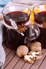 Mulled wine with orange and nuts on table close up