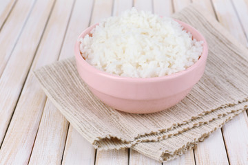 Cooked rice in bowl on wooden background