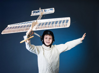 Fototapeta na wymiar Happy boy playing with a wooden plane model