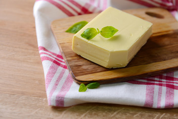Tasty butter on wooden cutting board