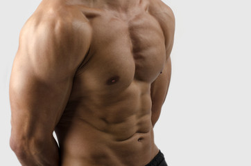Fototapeta na wymiar Bodybuilder with perfect abs, shoulders,biceps, triceps,chest