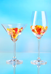 Goblets with pills on blue background