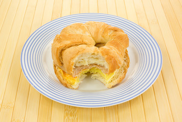 Bitten sausage egg and cheese croissant breakfast sandwich