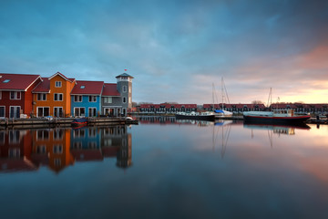 Fototapeta na wymiar sunrise over marina with buildings and boats