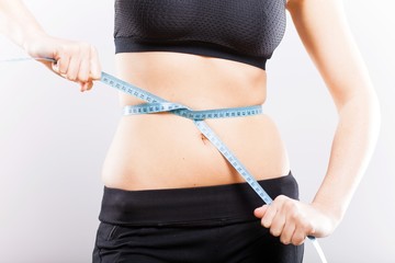 Woman measuring her waist, weight loss concept