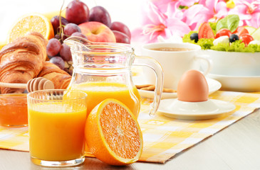 Breakfast with coffee, orange juice, croissant, egg, vegetables