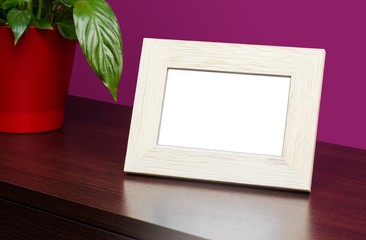 Blank wooden photo frame on the dresser
