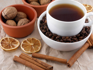 Cup of coffee with lemon, beans and cinnamon on old paper