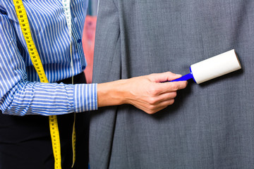 Textilreinigerin  in Wäscherei kontrolliert Kleidung 