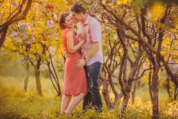 Fototapeta premium Portret młodej pary w kwitnącym parku