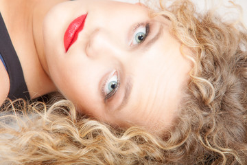 Portrait beautiful blond girl make up lying on floor studio shot