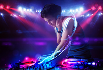 Fototapeta na wymiar Disc jockey playing music with light beam effects on stage