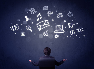 Businessman in chair with multimedia icons over his head