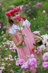 Rose garden - beautiful girl playing in the rose garden
