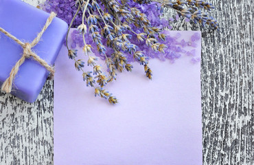 Lavender flower, soap, salt and blank paper on a wooden backgrou