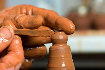 hands of a potter, creating an earthen jar