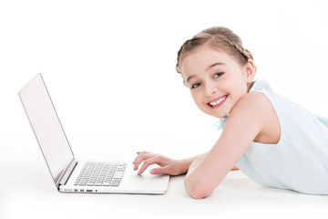 Little girl with silver color laptop.