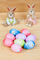 Funny rabbits ceramic with Easter eggs decorated with daisies
