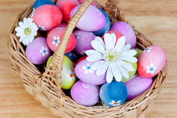Obraz na płótnie Canvas Easter eggs decorated with daisies tucked in a basket