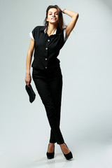 Fototapeta premium woman in black casual clothes standing on gray background