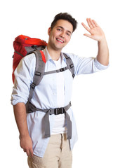 Lachender Backpacker winkt zur Kamera