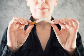 Woman quits smoking and breaking cigarette in half
