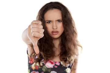 Angry girl showing thumbs down on white background