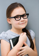Little girl is reading a book