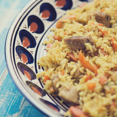 Close-up of uzbek traditional pilaf in a plate with ornaments